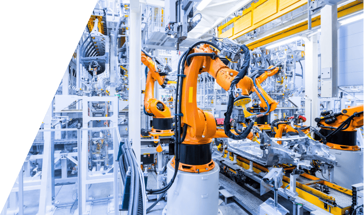 Orange robotic arms working on an automated manufacturing line.